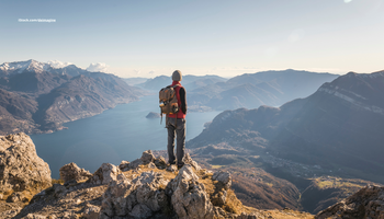 Das Foto zeigteinen Wanderer auf einem Berg mit Aussicht in die Ferne.