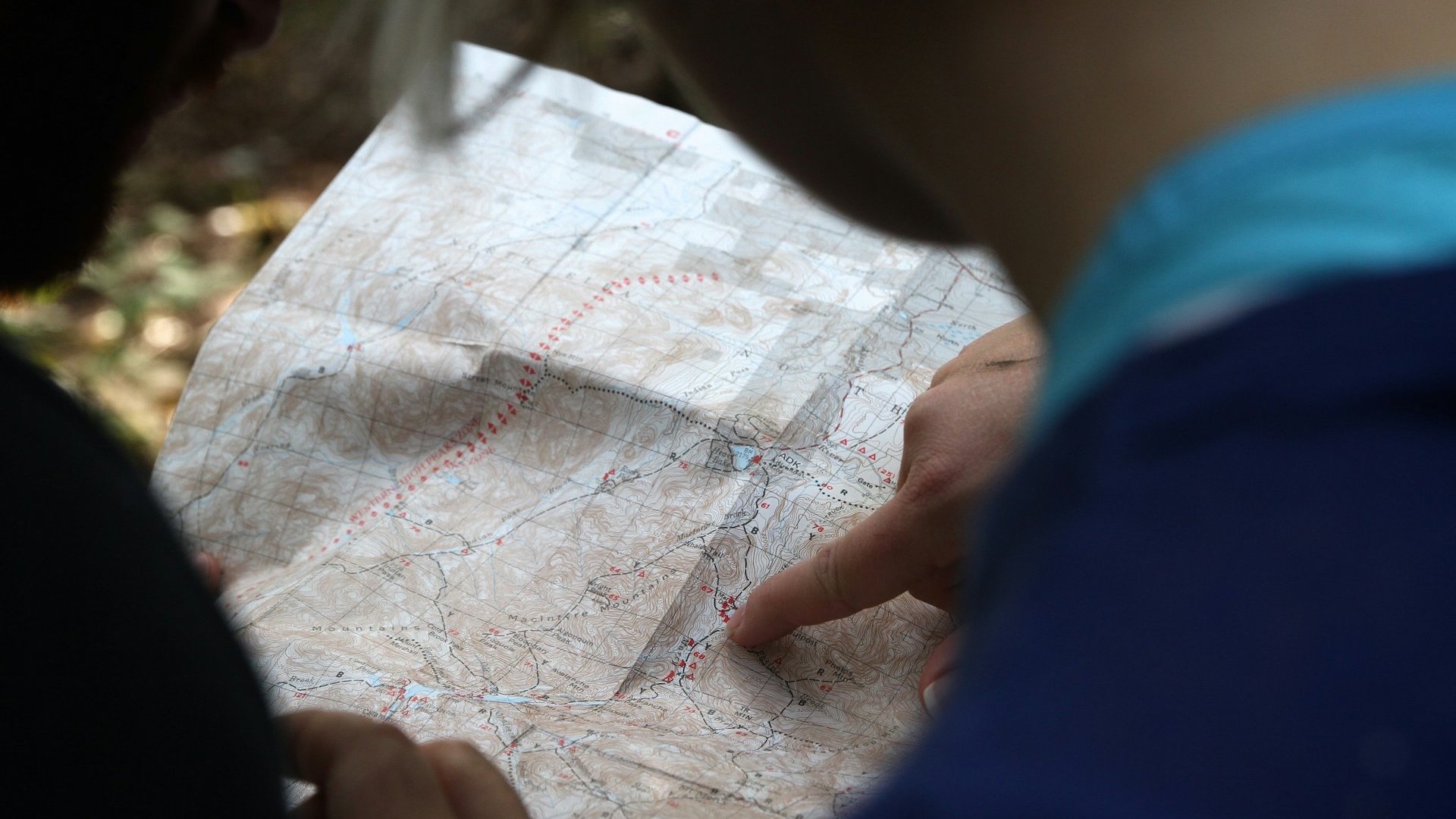 Das Foto zeigt zwei Personen, die eine Landkarte lesen.