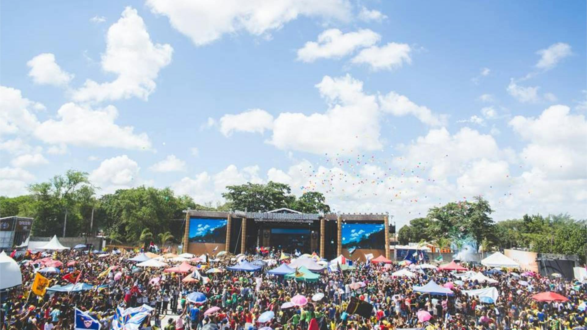 Eine gut besuchte Konzertbühne bei einem Open-Air-Festival bei gutem Wetter